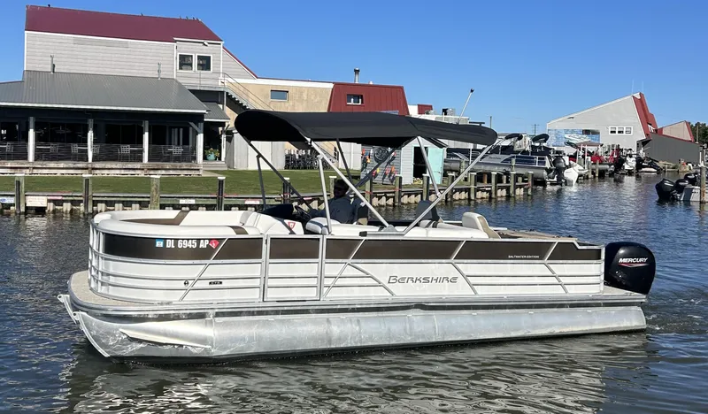 Slide: The Image of 2024 Berkshire 24RFC CTS 2.75 pontoon boat on a calm waterfront. - 19