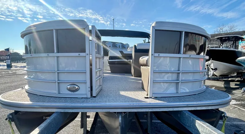 Slide: The Image of 2024 Berkshire 24RFC CTS 2.75 pontoon boat on trailer under clear blue sky. - 2