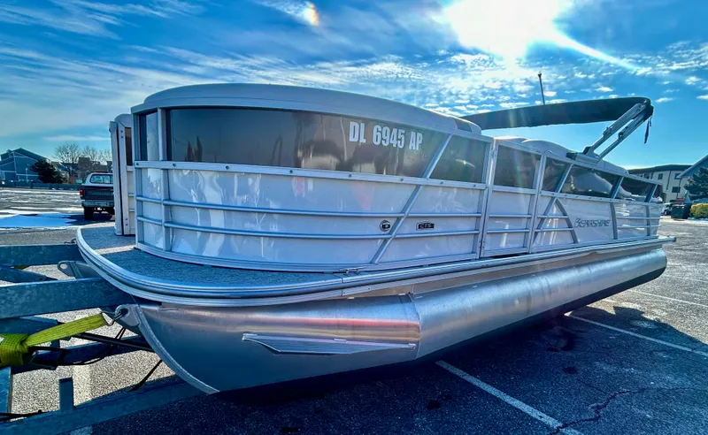 Slide: The Image of 2024 Berkshire 24RFC CTS 2.75 pontoon boat parked under a bright blue sky. - 3