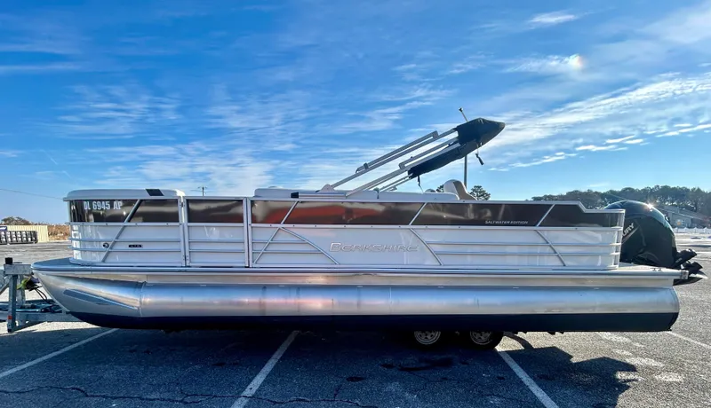Slide: The Image of 2024 Berkshire 24RFC CTS 2.75 pontoon boat parked under a clear blue sky. - 4