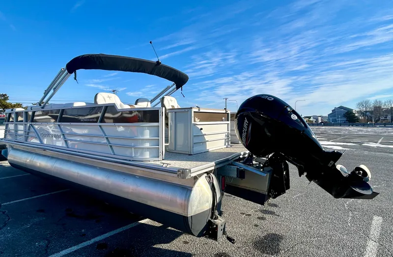 Slide: The Image of 2024 Berkshire 24RFC CTS 2.75 pontoon boat with outboard motor in parking lot. - 5