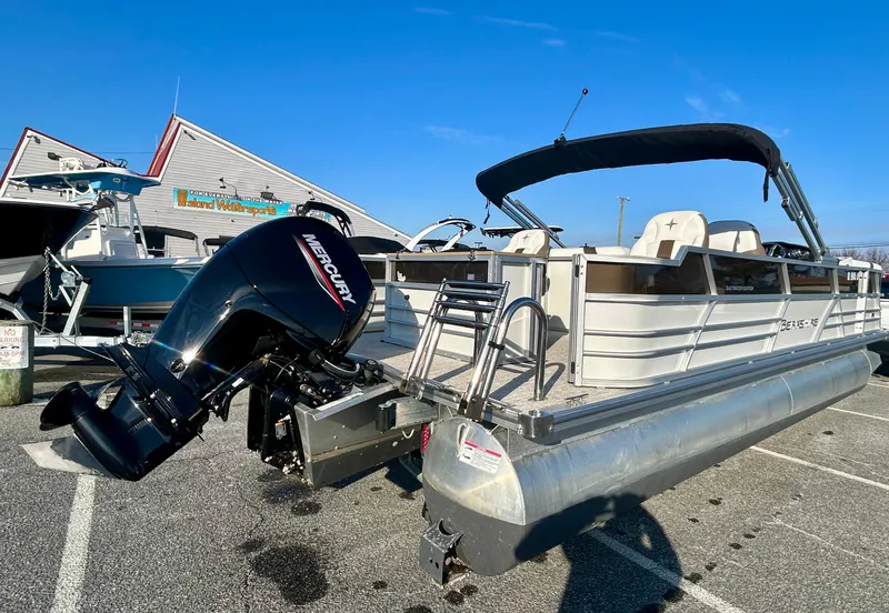 Slide: The Image of 2024 Berkshire 24RFC CTS 2.75 pontoon boat with Mercury outboard motor in a parking lot. - 7