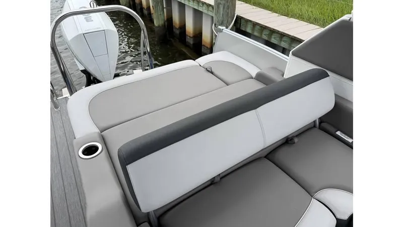 Slide: The Image of 2023 Avalon 2585 VRB boat with sleek gray seating and cup holder, docked by water. - 14