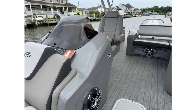 Slide: The Image of 2023 Avalon 2585 VRB boat interior with sleek seating and modern design on a calm waterway. - 17