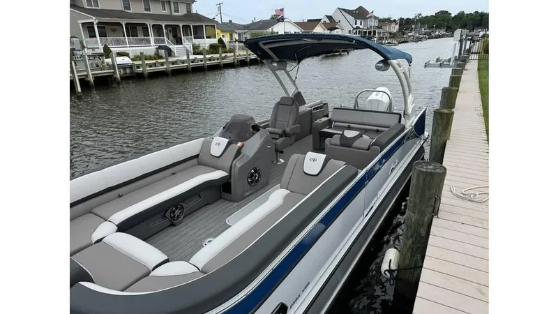 Slide: The Image of 2023 Avalon 2585 VRB pontoon boat docked by a canal, featuring spacious seating and modern design. - 20