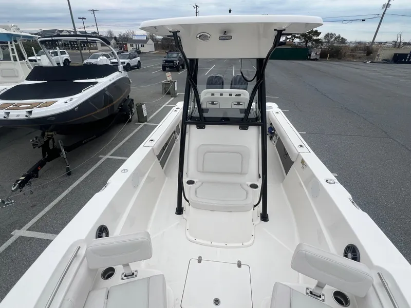 Slide: The Image of 2024 Sea Born LX24 LE boat interior with seating and console in a parking lot. - 13