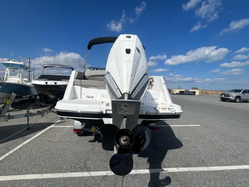Slide: The Image of 2024 Four Winns HD5 OB boat, rear view, parked on asphalt under blue sky. - 17