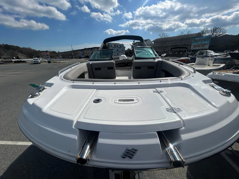 Slide: The Image of 2024 Four Winns HD5 OB boat, white exterior, parked outdoors under a partly cloudy sky. - 4