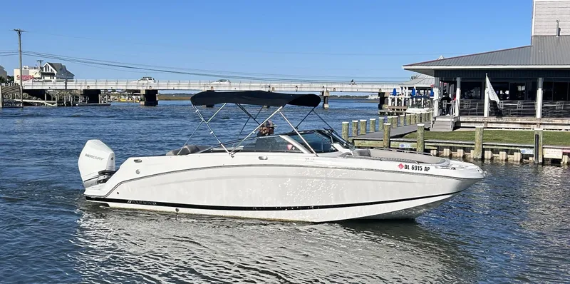 Slide: The Image of 2024 Four Winns HD5 OB boat cruising near a dock on a sunny day. - 6