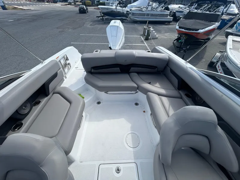 Slide: The Image of 2024 Four Winns HD5 OB boat interior with spacious seating in a marina setting. - 7