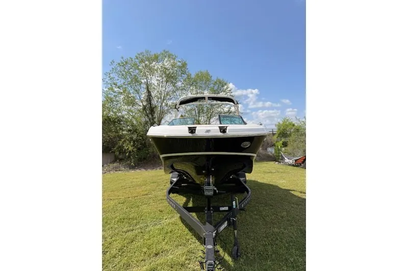 Slide: The Image of 2025 Four Winns HD3 boat on trailer, parked on grass under clear blue sky. - 18