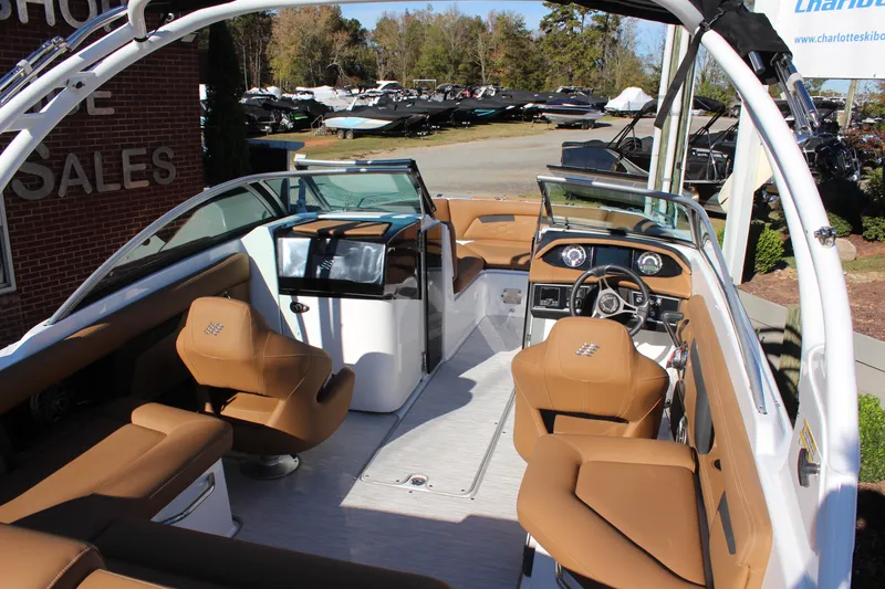 Slide: The Image of 2025 Four Winns HD3 boat interior with tan seating and modern dashboard. - 6