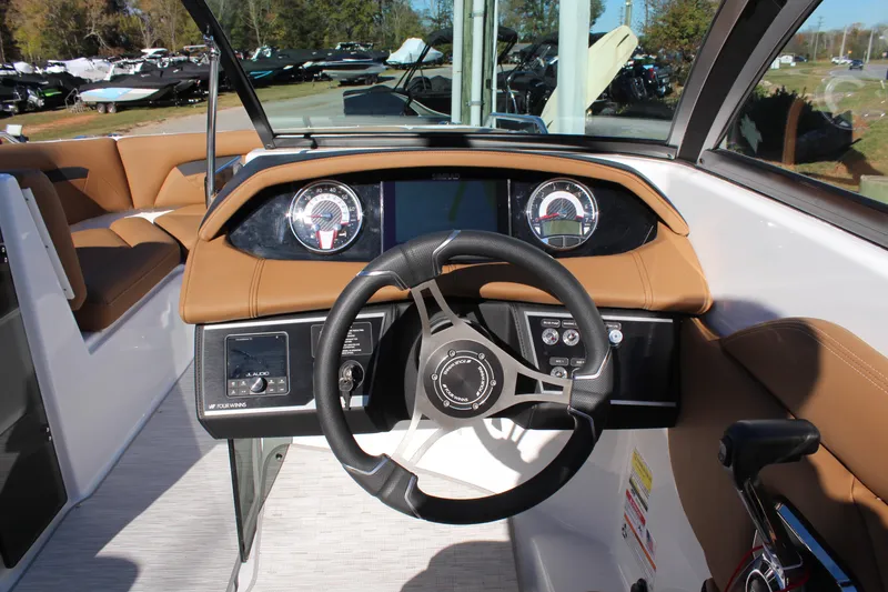 Slide: The Image of 2025 Four Winns HD3 boat dashboard with steering wheel and modern controls. - 9