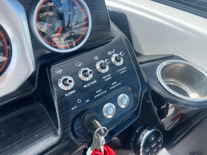 Slide: The Image of Control panel of a 2024 Scarab 255 ID boat with switches and speedometer. - 19