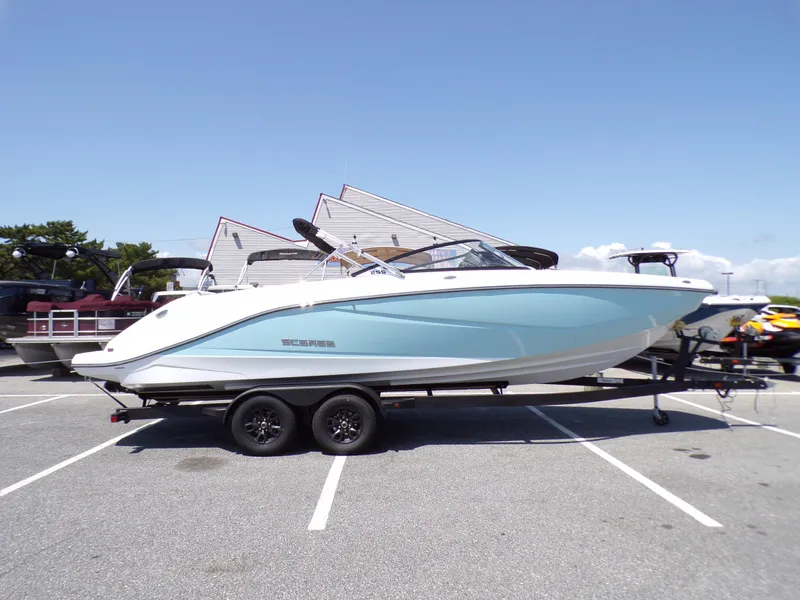 Slide: The Image of 2024 Scarab 255 ID boat on trailer in parking lot, side view. - 2
