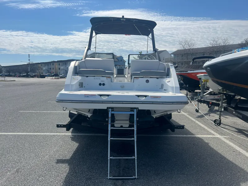 Slide: The Image of 2024 Scarab 255 ID boat, rear view, parked on trailer in sunny lot. - 25