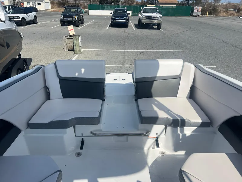 Slide: The Image of 2024 Scarab 255 ID boat interior with gray and white seating in a parking lot. - 5