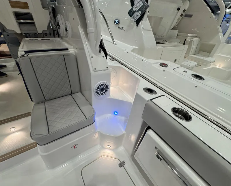 Slide: The Image of 2025 Pursuit OS 325 Offshore boat interior with seating and ambient lighting. - 12