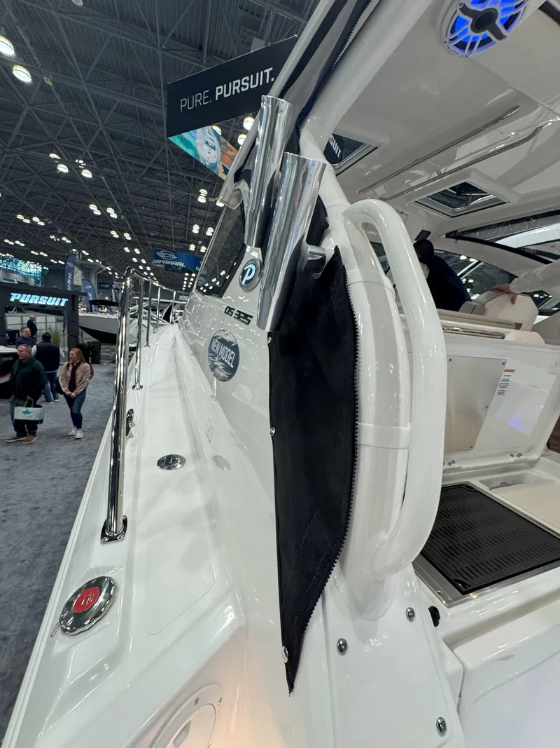 Slide: The Image of 2025 Pursuit OS 325 Offshore boat showcased at an indoor exhibition. - 13
