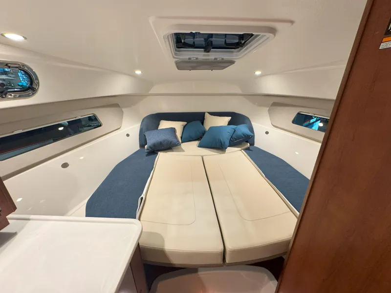 Slide: The Image of 2025 Pursuit OS 325 Offshore cabin interior with bed and cushions. - 21