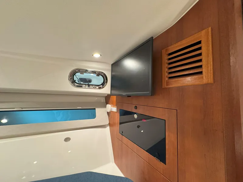 Slide: The Image of Interior cabin of 2025 Pursuit OS 325 Offshore with TV and porthole window. - 24
