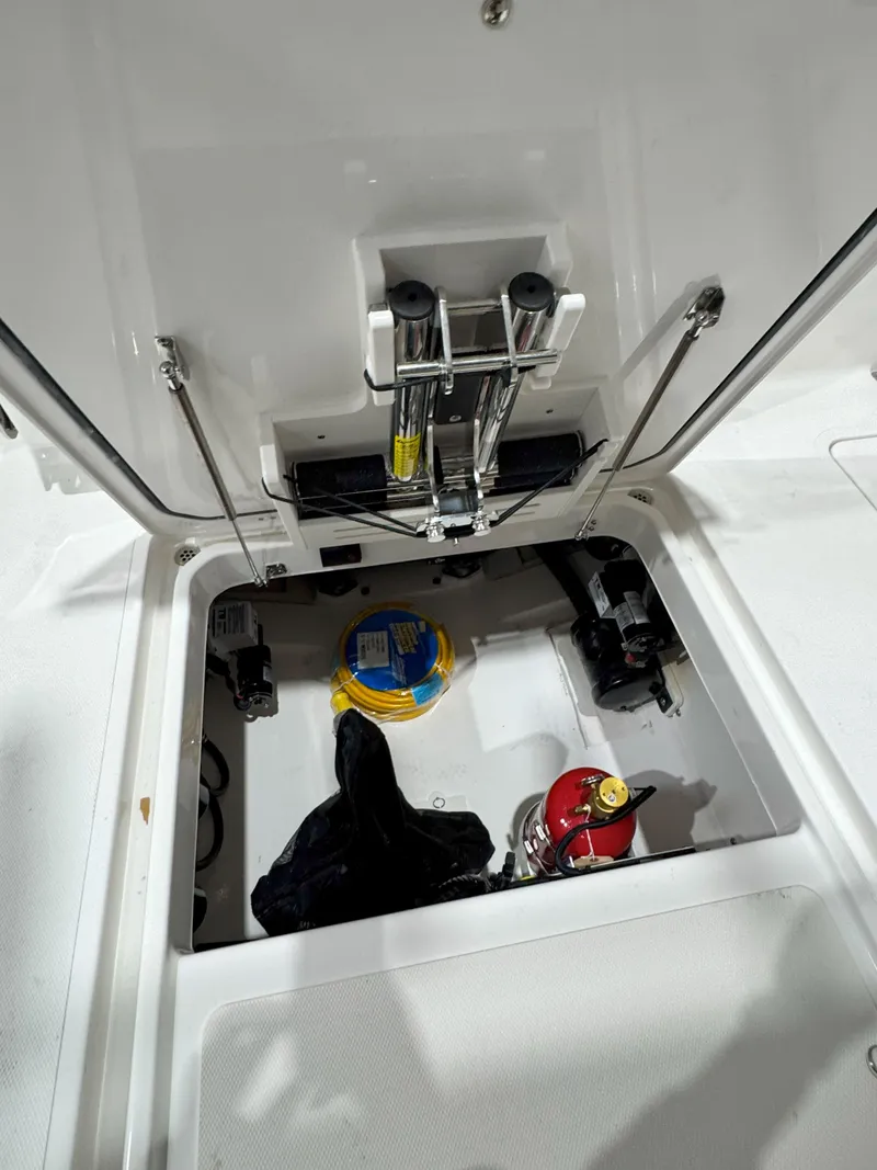 Slide: The Image of 2025 Pursuit OS 325 Offshore boat storage compartment with equipment and fire extinguisher. - 8