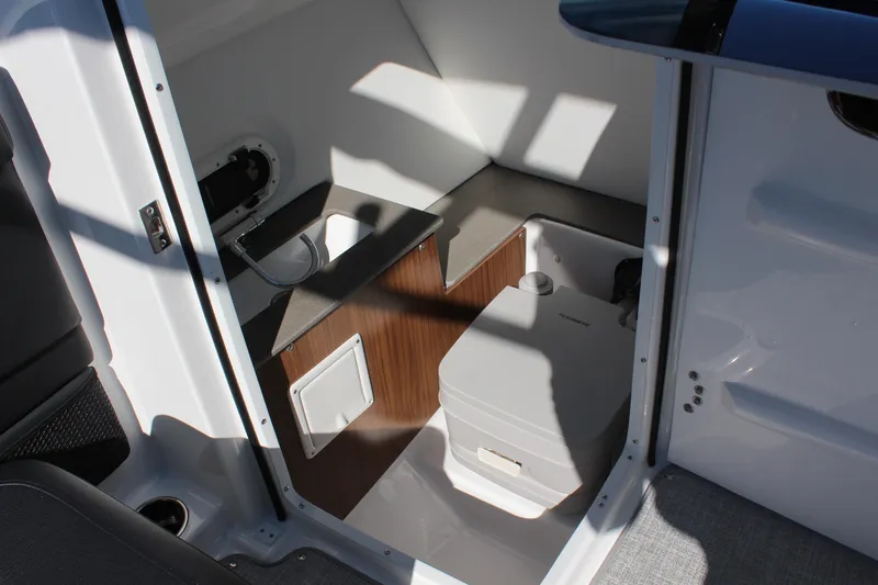 Slide: The Image of 2025 Four Winns HD5 boat interior with compact bathroom and modern amenities. - 14