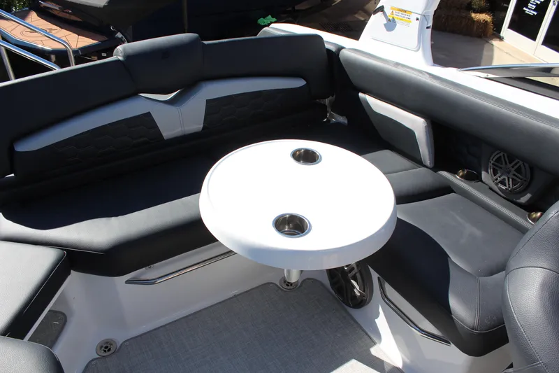 Slide: The Image of 2025 Four Winns HD5 boat interior with round table and cushioned seating. - 15