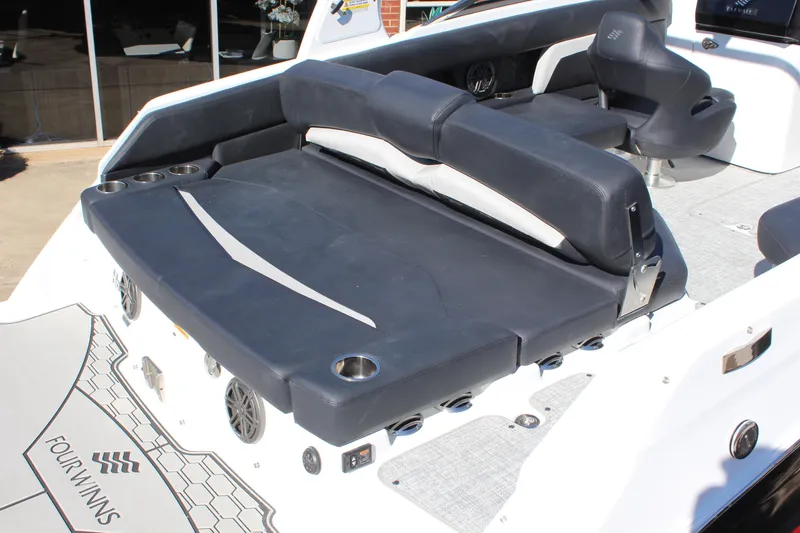 Slide: The Image of 2025 Four Winns HD5 boat interior with black seating and cup holders. - 6