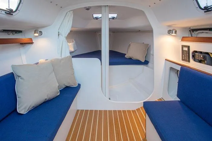 Slide: The Image of Interior of 2026 J Boats J/9 sailboat with blue seating and wood flooring. - 4