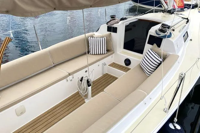 Slide: The Image of 2026 J Boats J/9 sailboat with beige seating and striped cushions on deck. - 5