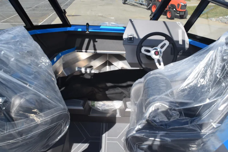 Slide: The Image of 2024 Stabicraft 1850 Fisher Sportfish interior with steering wheel and covered seats. - 8