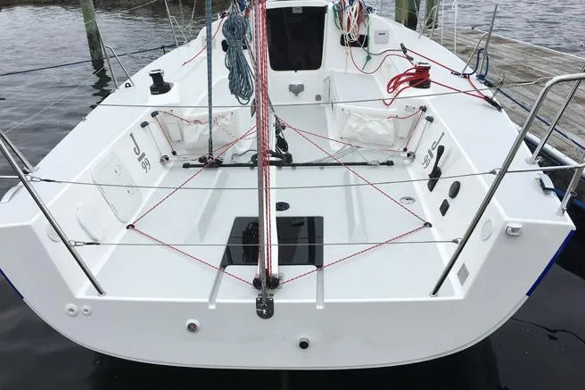 Slide: The Image of 2026 J Boats J/99 sailboat deck with rigging and ropes, docked at marina. - 7