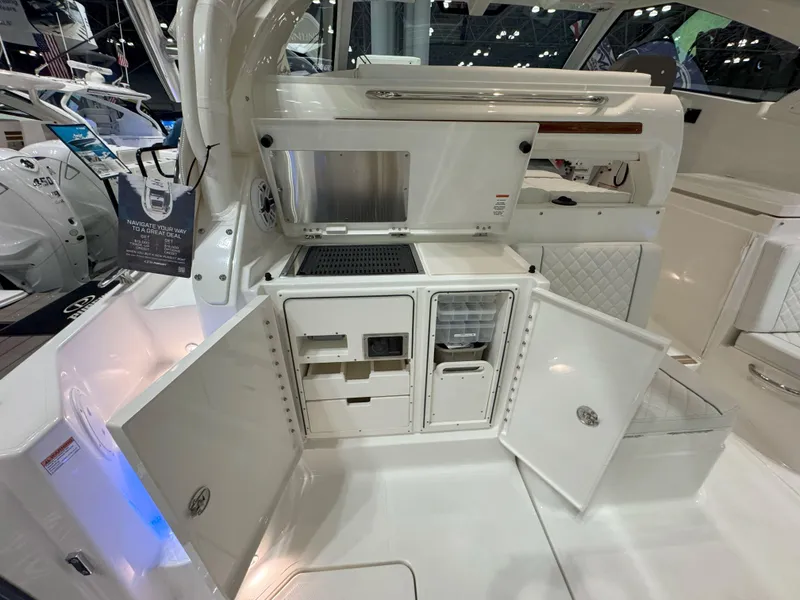 Slide: The Image of 2025 Pursuit OS 405 Offshore boat cruising on a serene lake with lush green shoreline. - 10