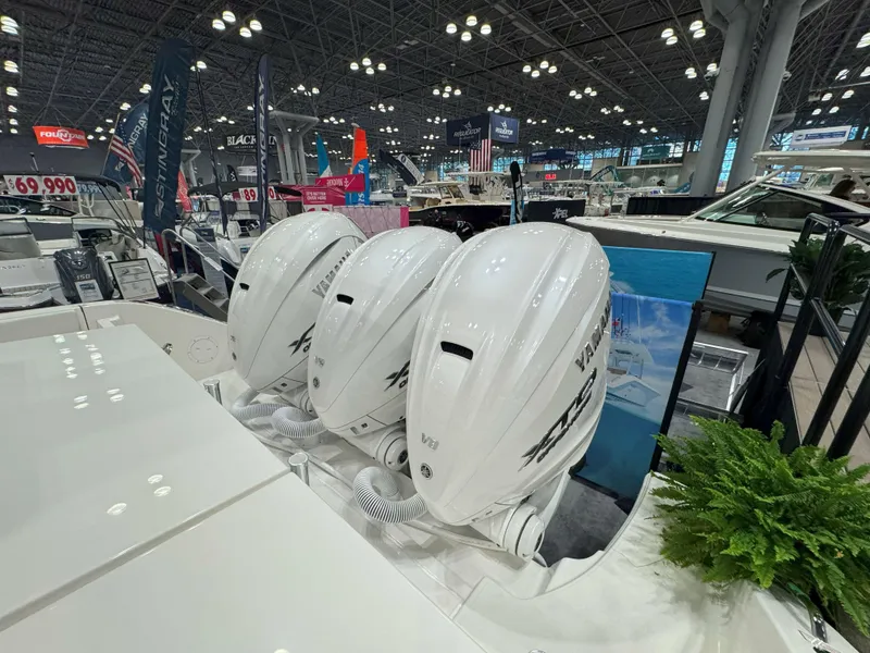 Slide: The Image of 2025 Pursuit OS 405 Offshore boat on a serene lake with lush green shoreline. - 3