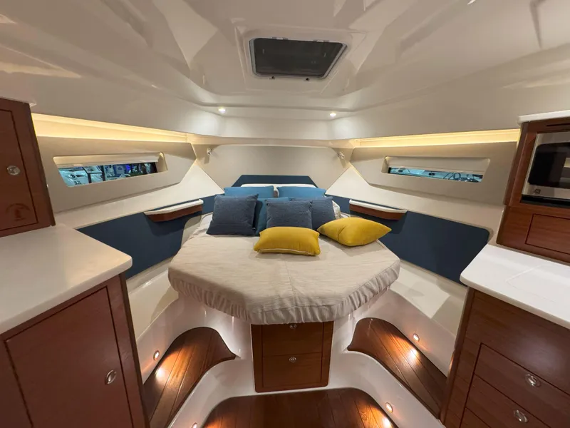Slide: The Image of Luxurious cabin interior of 2025 Pursuit OS 405 boat with cozy bed and ambient lighting. - 36
