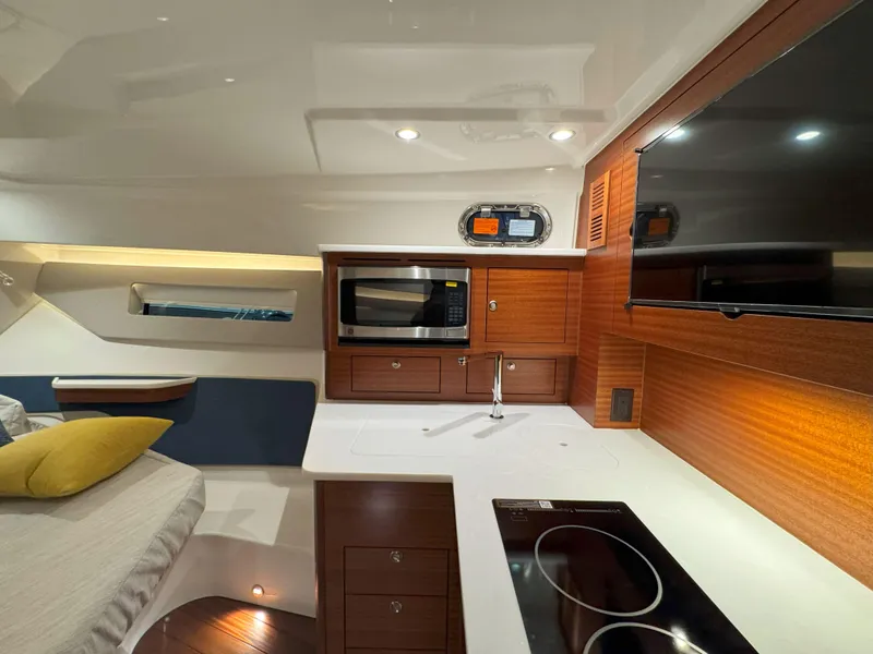 Slide: The Image of Interior of 2025 Pursuit OS 405 boat with modern kitchen and cozy seating area. - 38