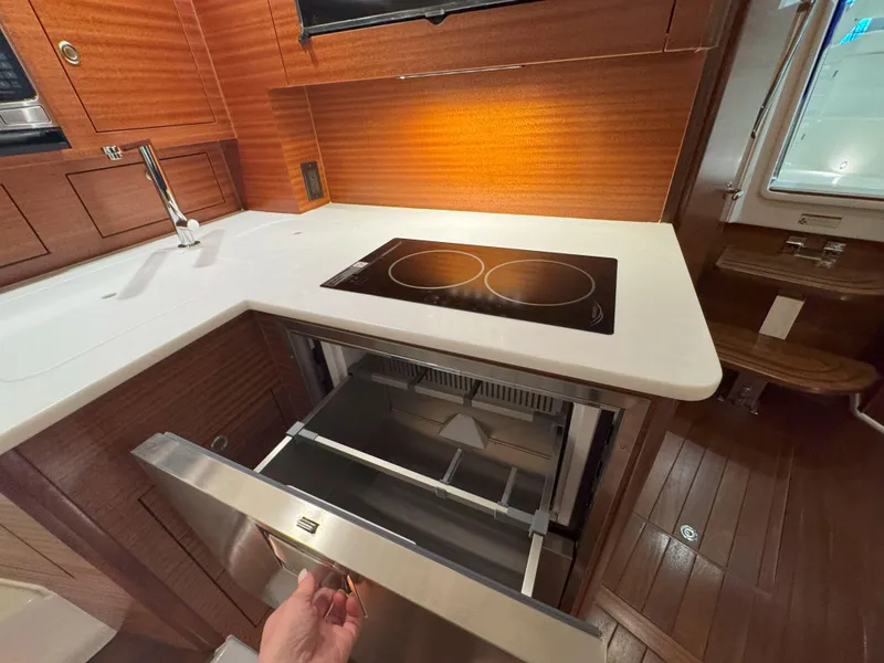 Slide: The Image of Modern kitchen in 2025 Pursuit OS 405 boat with induction cooktop and drawer-style fridge. - 40