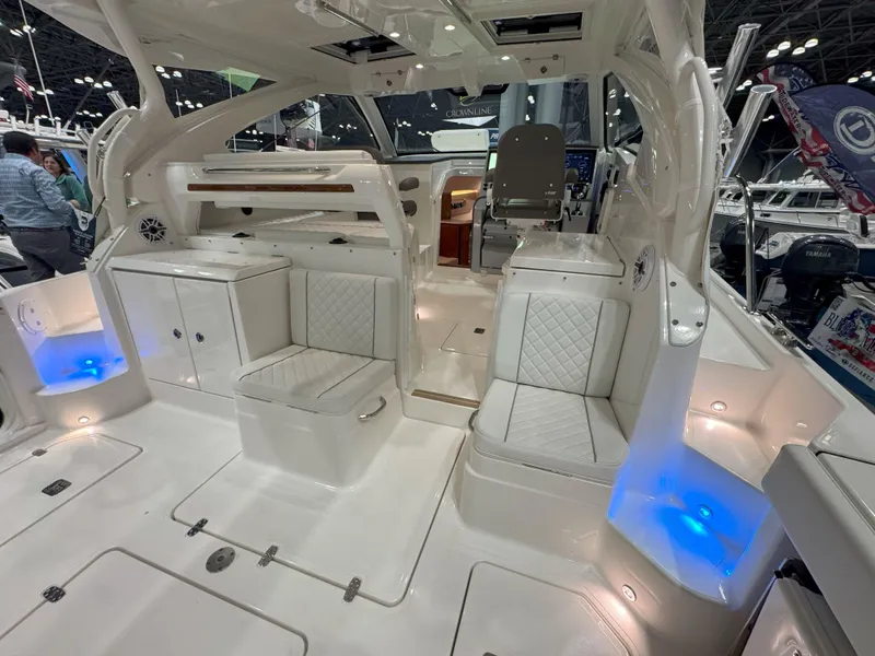 Slide: The Image of 2025 Pursuit OS 405 Offshore boat on calm water, surrounded by trees. - 9