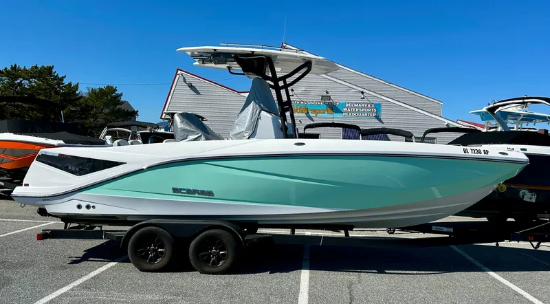 The Image of 2024 Scarab 255 Open boat on trailer, displayed outdoors under clear blue sky. - 0