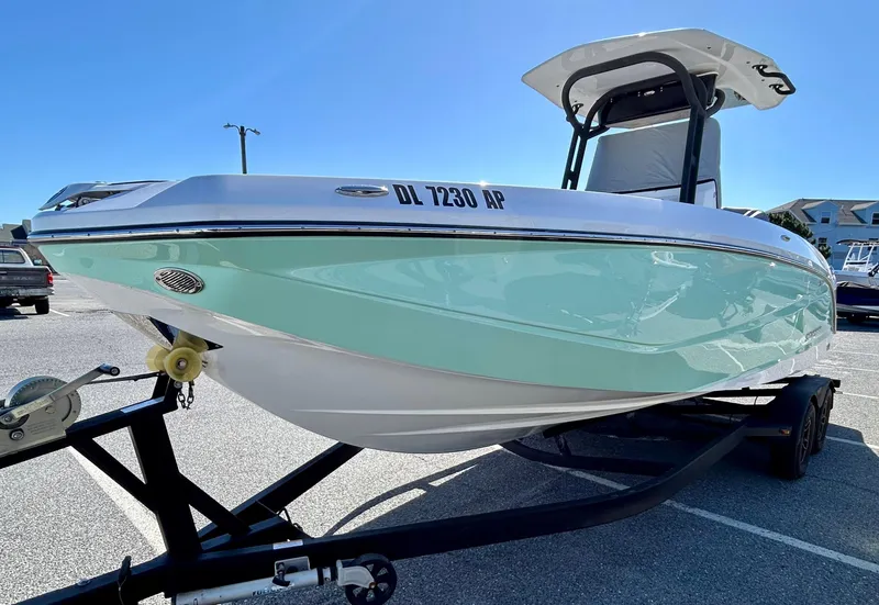 Slide: The Image of 2024 Scarab 255 Open boat on trailer, mint green hull, parked outdoors. - 2