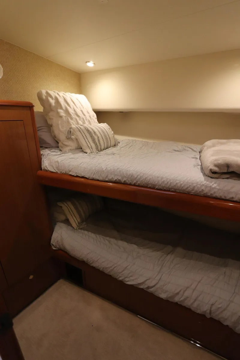 Slide: The Image of Bunk beds in a 2000 Viking 65 yacht cabin with cozy lighting. - 12