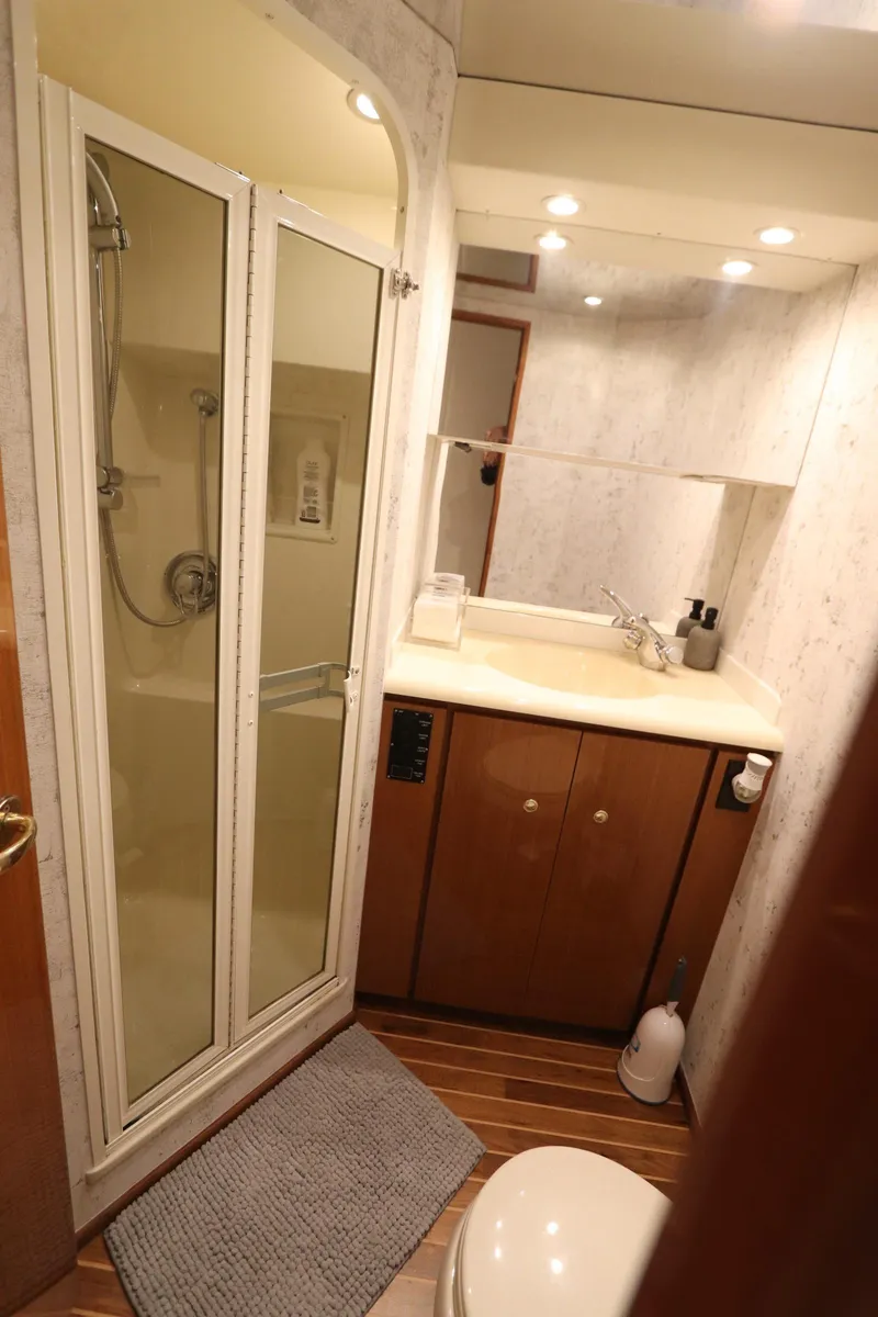 Slide: The Image of Bathroom interior of a 2000 Viking 65 yacht with shower and wooden cabinetry. - 13