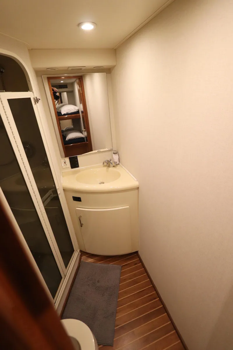 Slide: The Image of Compact bathroom in a 2000 Viking 65 yacht with modern fixtures and wooden flooring. - 15