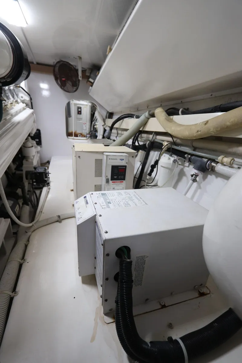 Slide: The Image of Engine room of a 2000 Viking 65 yacht, featuring machinery and piping. - 23