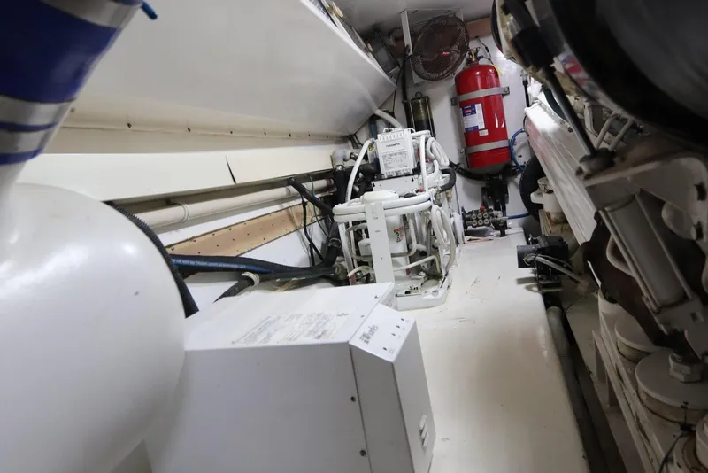 Slide: The Image of Engine room of a 2000 Viking 65 yacht, featuring machinery and fire safety equipment. - 26