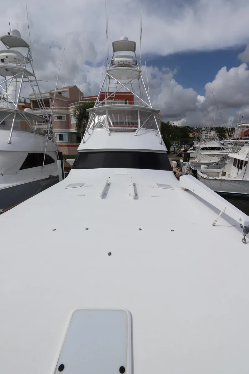 Slide: The Image of 2000 Viking 65 yacht docked in marina, showcasing sleek design and spacious deck. - 27