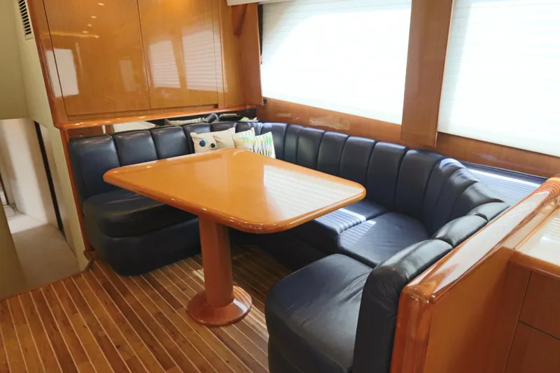Slide: The Image of Luxurious interior of a 2000 Viking 65 yacht with leather seating and wooden table. - 5