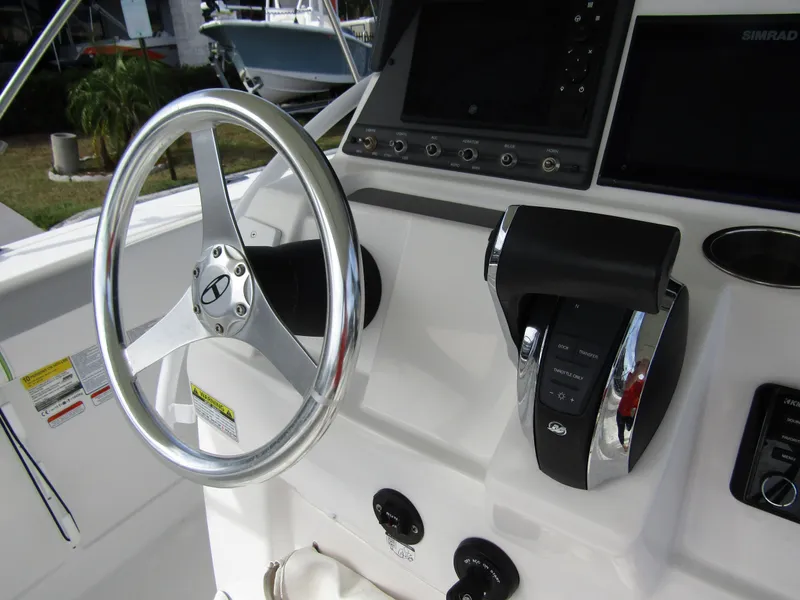 Slide: The Image of 2022 Tahoe 2150 CC boat dashboard with steering wheel and controls. - 24
