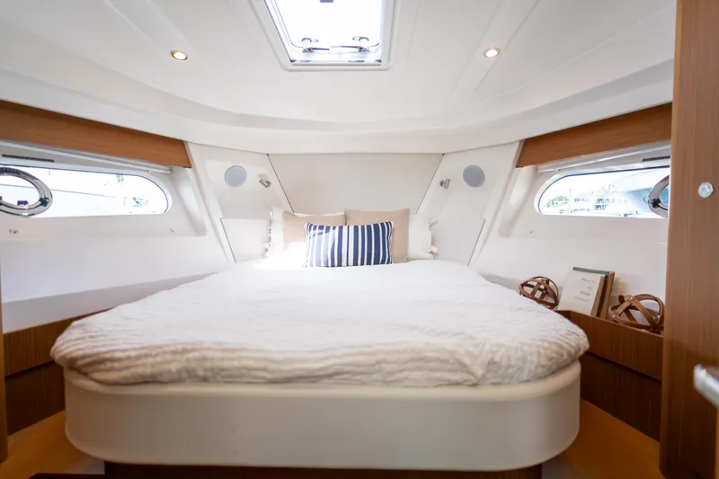 Slide: The Image of 2023 Beneteau Swift Trawler 35 cabin with cozy bed and nautical decor. - 12